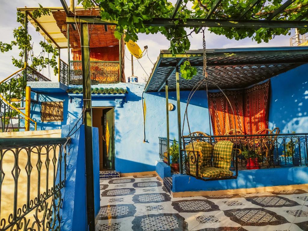 ein blaues Haus mit einem Stuhl auf dem Balkon in der Unterkunft Dar Rihanne in Fès