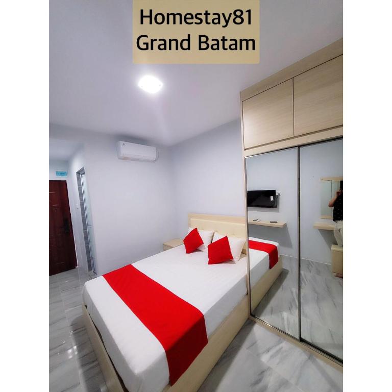 a bedroom with a bed with a red and white blanket at Homestay 81 Grand Batam in Nagoya