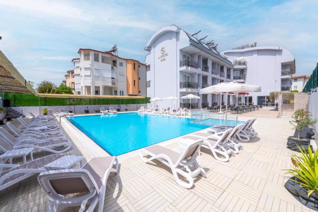 a swimming pool with lounge chairs and a hotel at A Hotel Side in Side