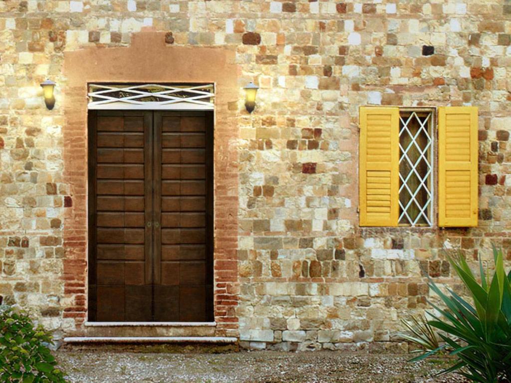 una porta e una finestra su un edificio di mattoni di Casa della Ludo B&B a SantʼAntonino