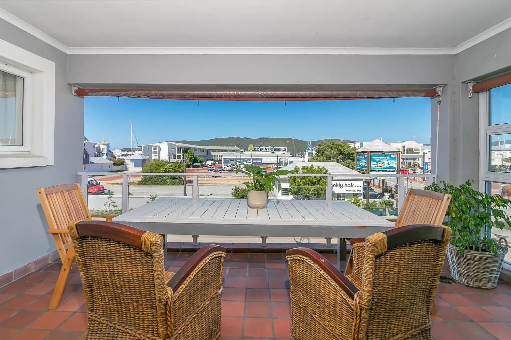 a dining room with a table and chairs on a balcony at Waterfront Delight in Knysna