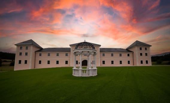 ein großes Gebäude mit einem Pavillon auf einem Grasfeld in der Unterkunft Château Šanov in Šanov