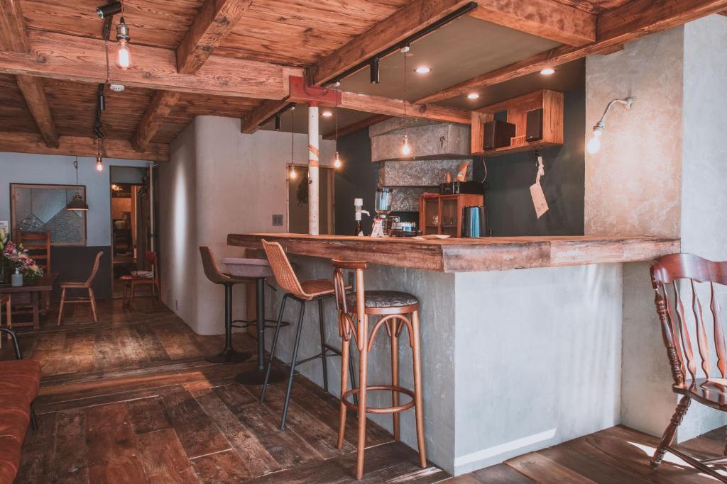 a bar in the middle of a room with wooden ceilings at ゲストハウスまたたび in Matsumoto