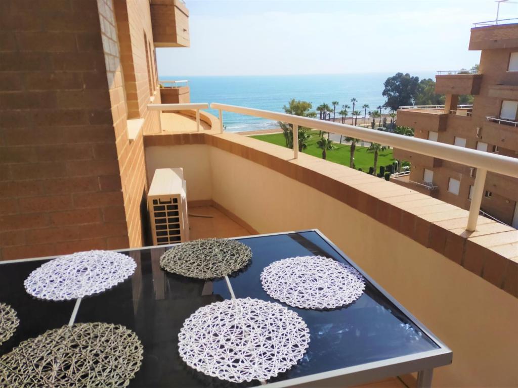 drie parasols op een tafel op een balkon bij ACV - Costa Marina II - 1ª linea planta 6 sur in Oropesa del Mar