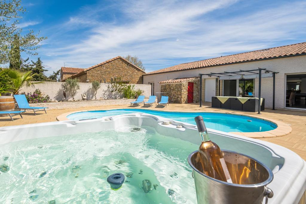 uma banheira de hidromassagem com uma garrafa de vinho em Villa avec piscine et Jaccuzy em Bize-Minervois