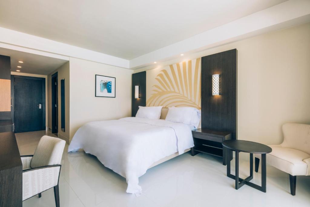 a bedroom with a bed and a table and a chair at Iberostar Selection Kuriat Palace in Monastir