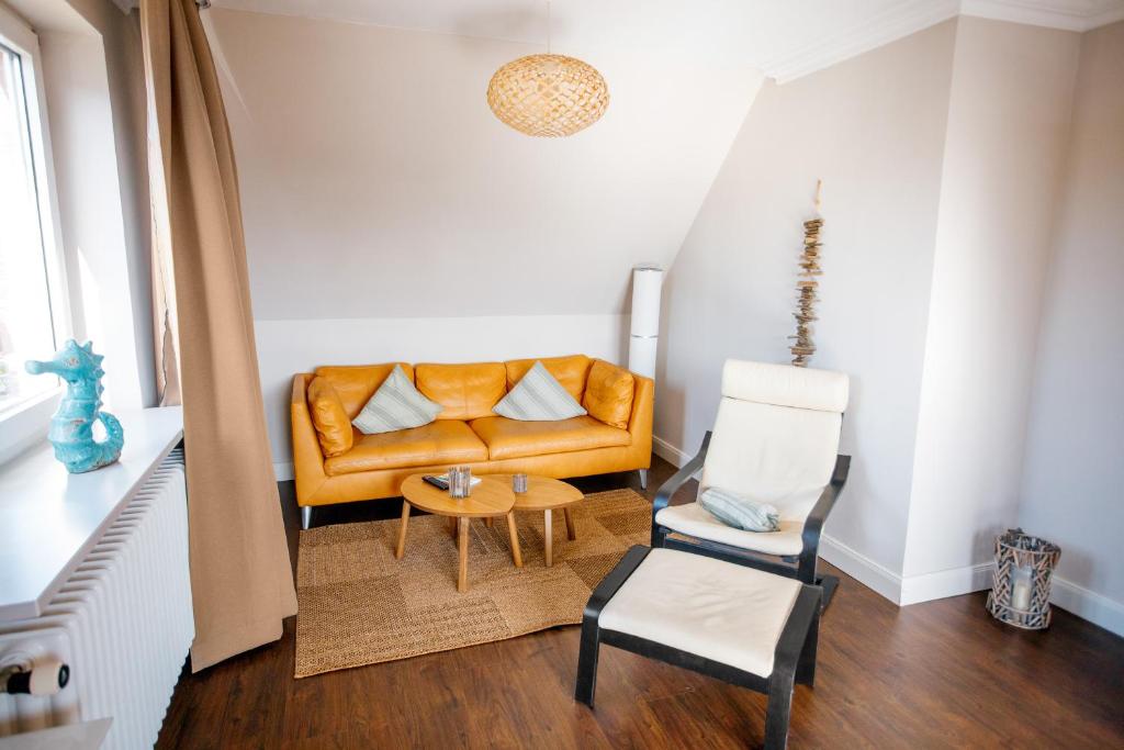ein Wohnzimmer mit einem Sofa und einem Stuhl in der Unterkunft Ferienwohnung Nr. 9 in Borkum
