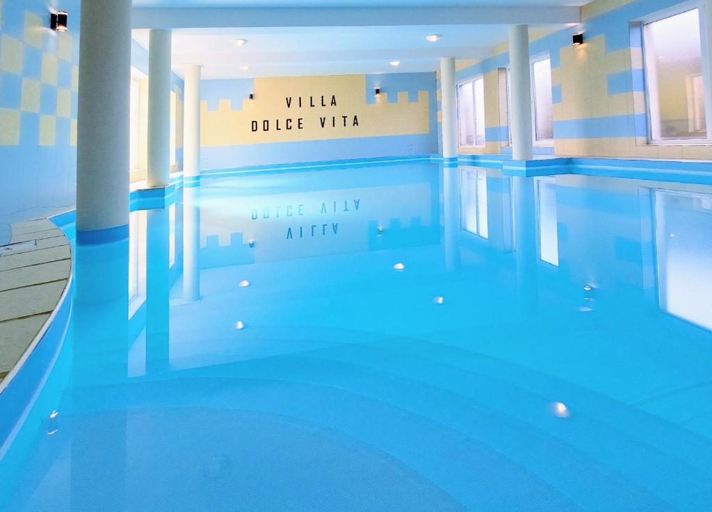 una piscina con un cartel que lee Villa Ridge Villa Jug inn en Villa Dolce Vita, en Łeba