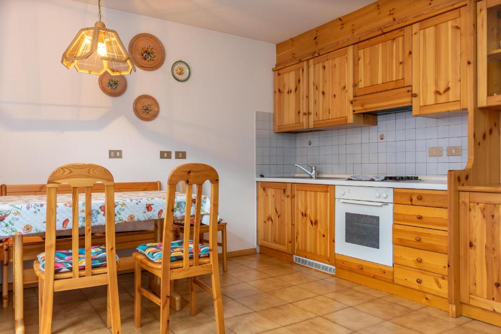 a kitchen with wooden cabinets and a table and chairs at Casa Maura in Soraga