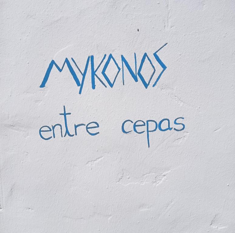 una escritura en el costado de una pared blanca en MYKONOS entre cepas, en Sanlúcar de Barrameda