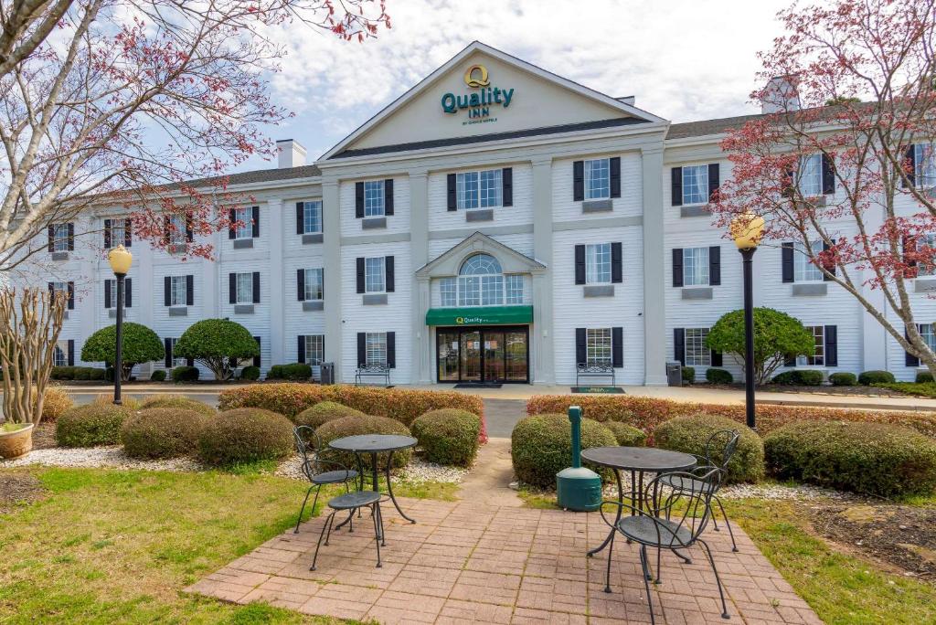 un edificio con mesas y sillas delante de él en Quality Inn Newnan, en Newnan