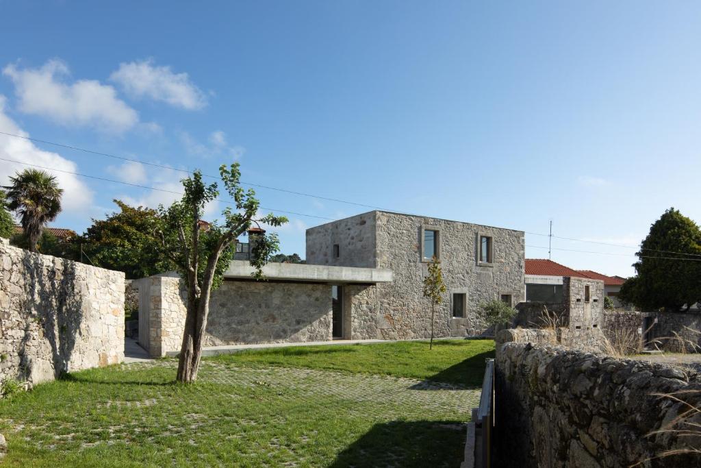 una vista exterior de la casa con una pared de piedra en Casa dos Cabeçudos, en Afife