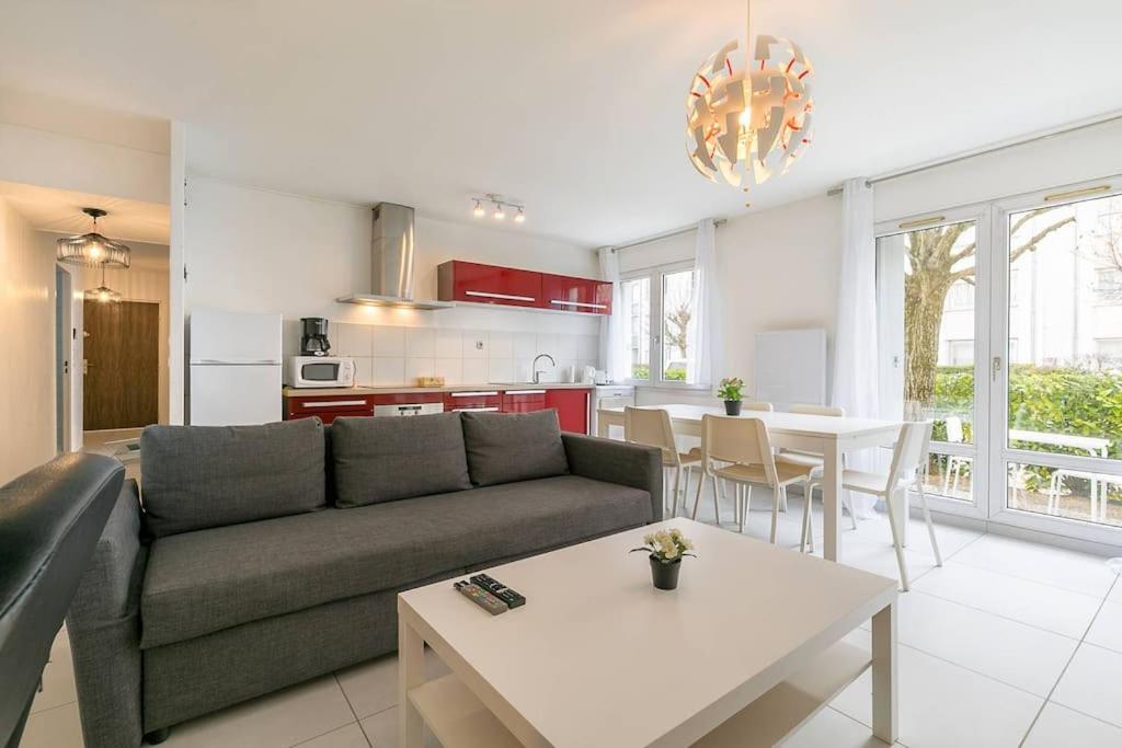 een woonkamer met een bank en een tafel bij Le Marpaux in Dijon