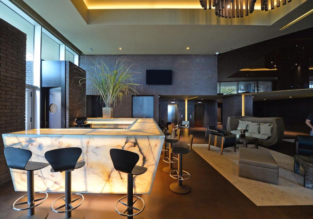 a lobby with a bar with stools around it at Saccharum - Resort and Spa - Savoy Signature in Calheta