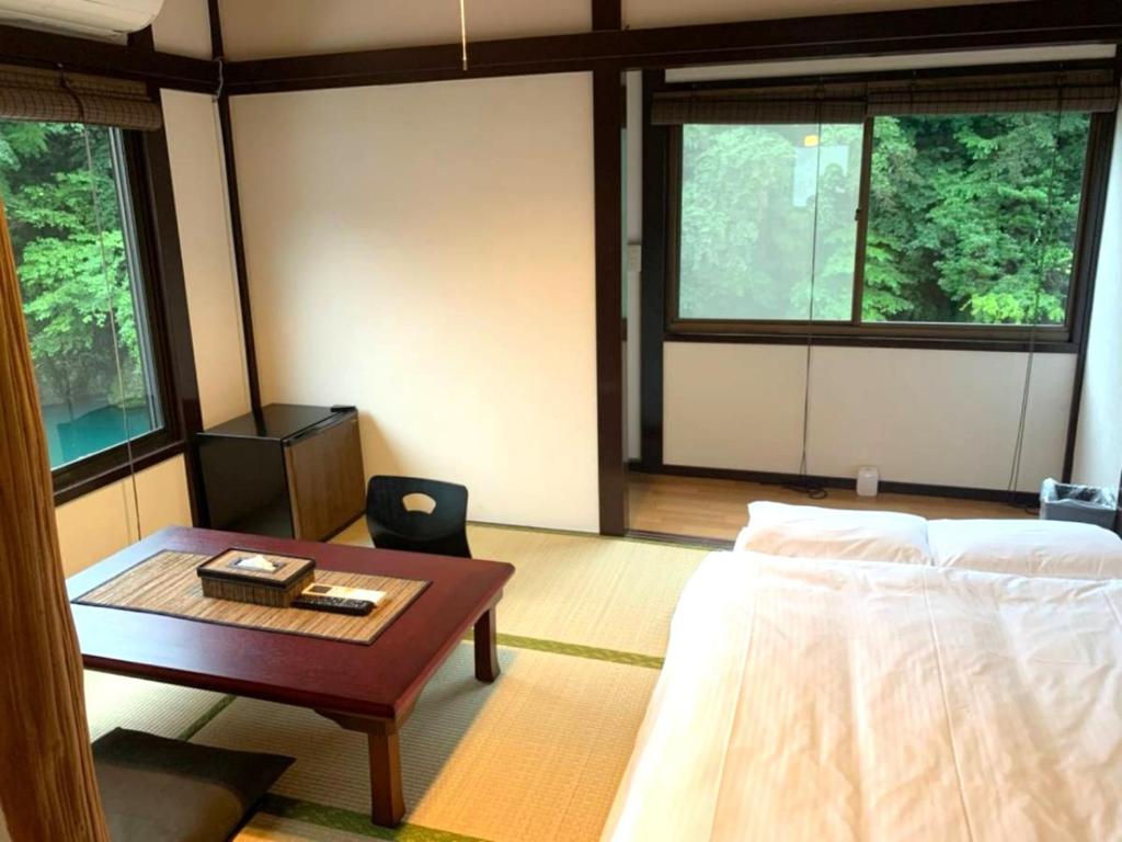 a room with a bed and a table with a coffee table at SyunkaSyuutou - Vacation STAY 53638v in Hakone