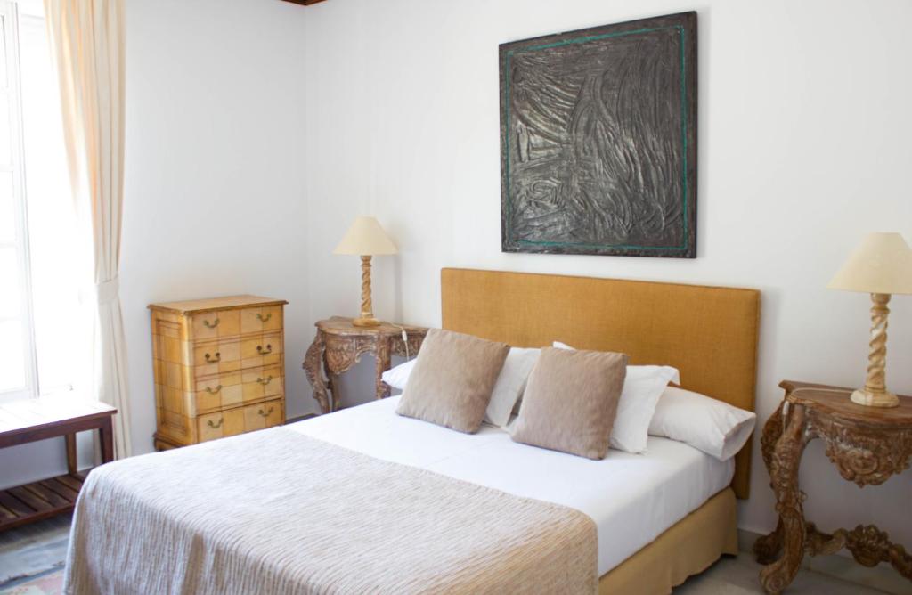 a bedroom with a large bed with white sheets and pillows at Hotel Hacienda Montenmedio in Vejer de la Frontera