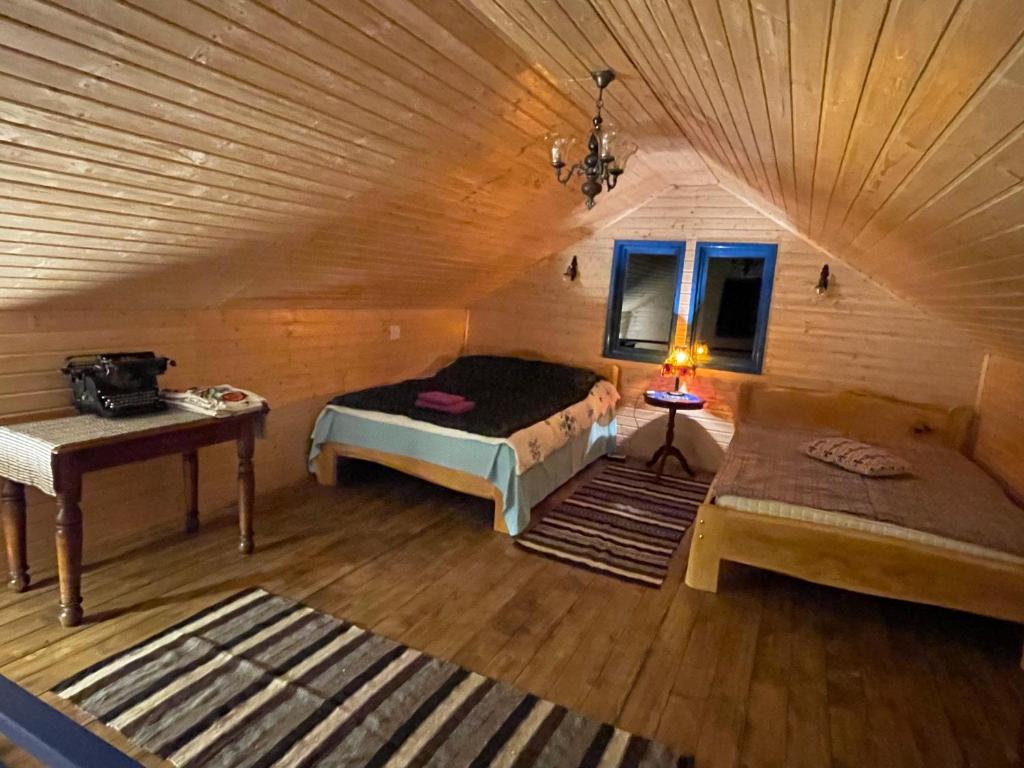 Un dormitorio con una cama y una mesa en una habitación. en Casa Brună, en Băile Olăneşti