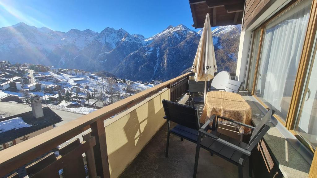 a balcony with a table and chairs and mountains at Pension Taverne in Grächen
