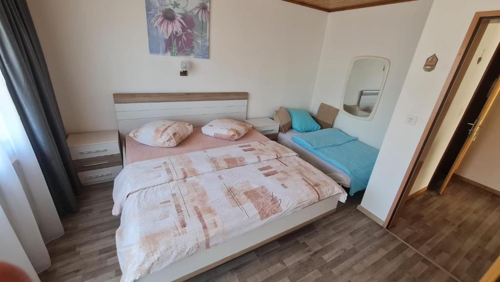 małą sypialnię z łóżkiem i lustrem w obiekcie Pension Taverne w mieście Grächen