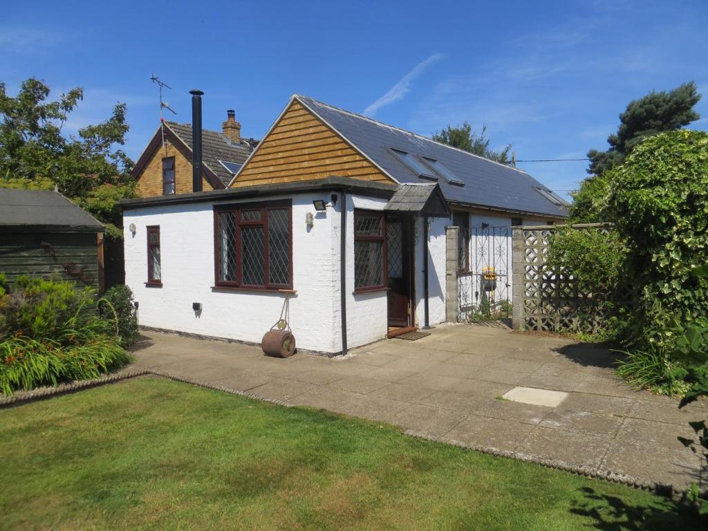 una casa blanca con entrada en un patio en Willow Cottage, en Dersingham