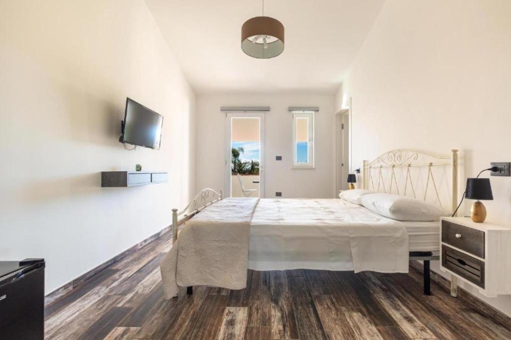 1 dormitorio blanco con 1 cama y TV en Elios Rooms, en Nardò