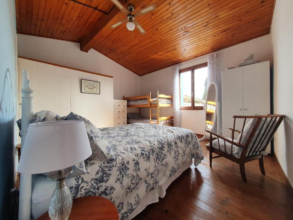 een slaapkamer met een bed, een lamp en een stoel bij Bonnie Maison in Alaigne