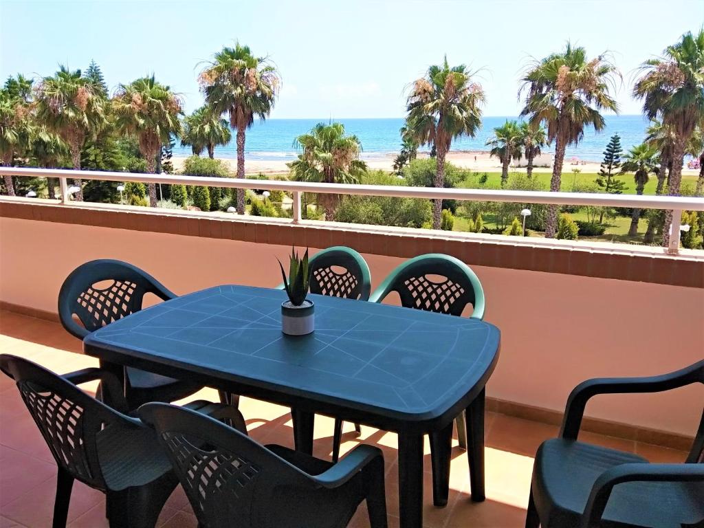 una mesa azul y sillas en un balcón con vistas a la playa en ACV - Vistamar III-1ª línea planta 2 Frontal, en Oropesa del Mar
