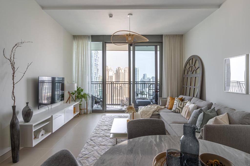 een woonkamer met een bank en een tafel bij HiGuests - Stylish Apartment Floating Over The Marina Waters in Dubai