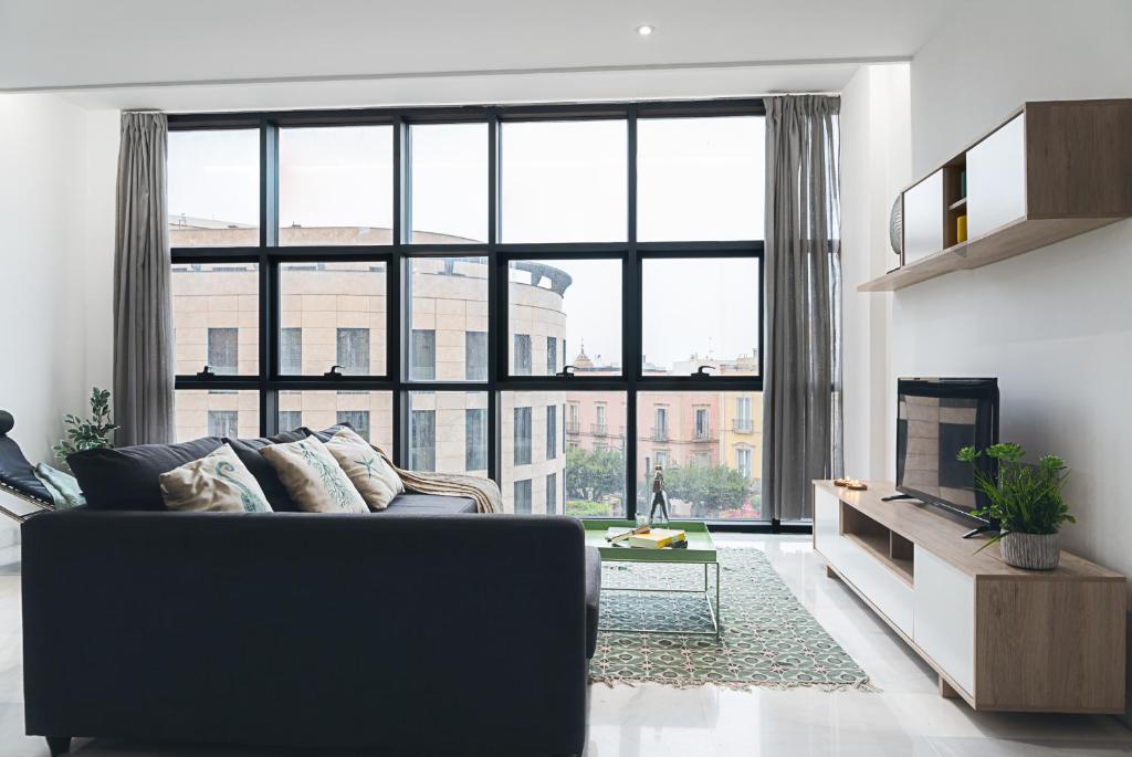 un soggiorno con divano e una grande finestra di Puerta de Purchena - Lux&Cool - apartamento a Almería