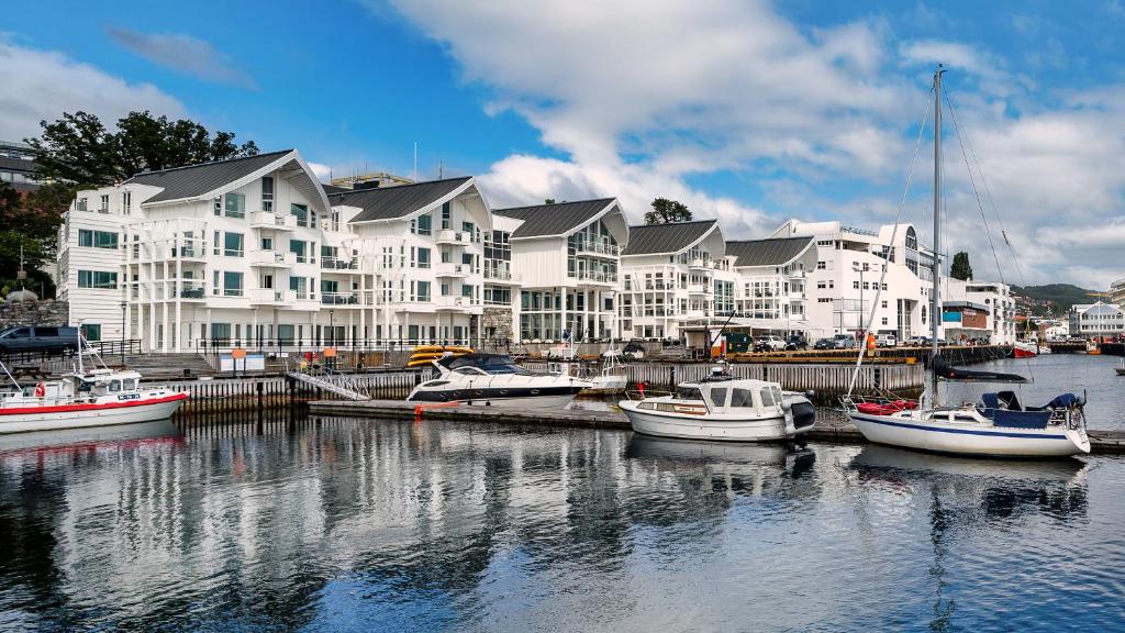 eine Gruppe von Booten, die in einem Yachthafen mit Gebäuden angedockt sind in der Unterkunft Molde Fjordhotell - by Classic Norway Hotels in Molde