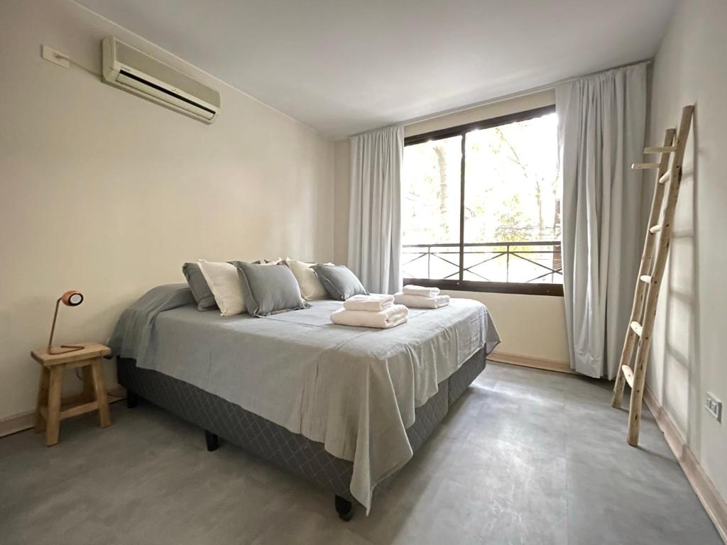 a bedroom with a bed with a ladder and a window at Departamento en Edificio Presidente Plaza España in Mendoza