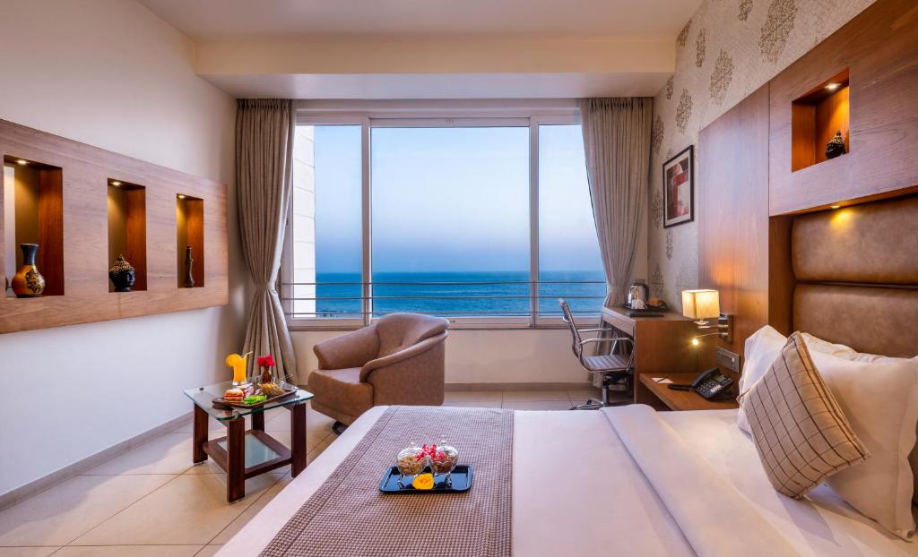 a hotel room with a bed and a view of the ocean at Dwarkadhish Lords Eco Inn in Dwarka