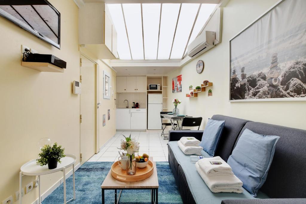 - un salon avec un canapé bleu et une lucarne dans l'établissement Cozy studio - 2P - Close to Sacré-Cœur, à Paris