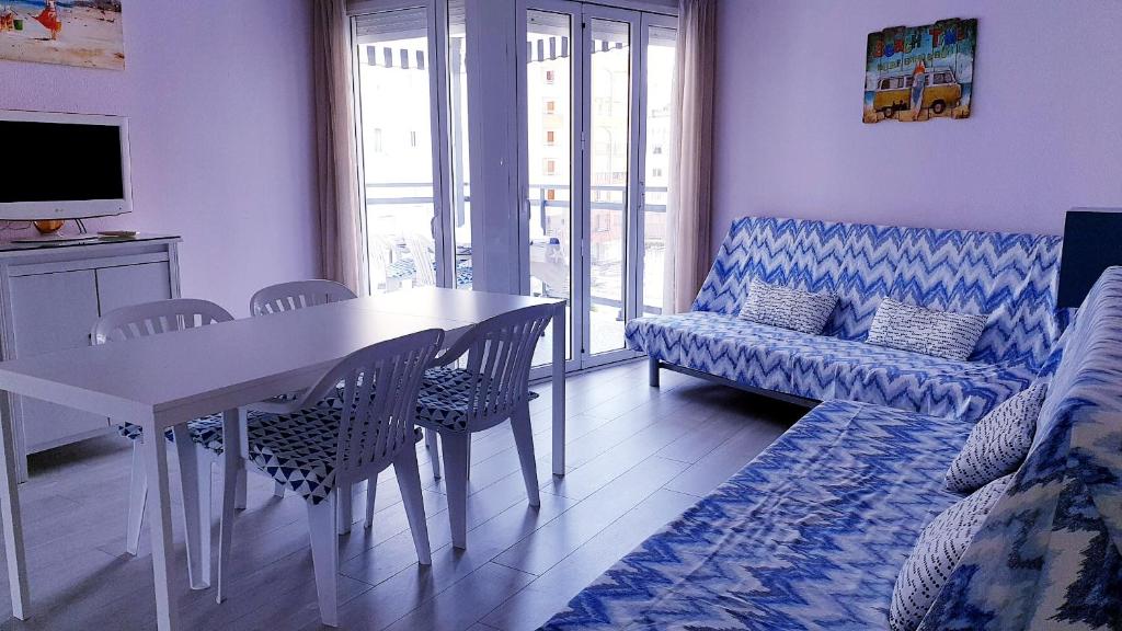 ein Wohnzimmer mit einem Tisch und einem Sofa in der Unterkunft Apartamento playa LLevant mejor zona Salou in Salou