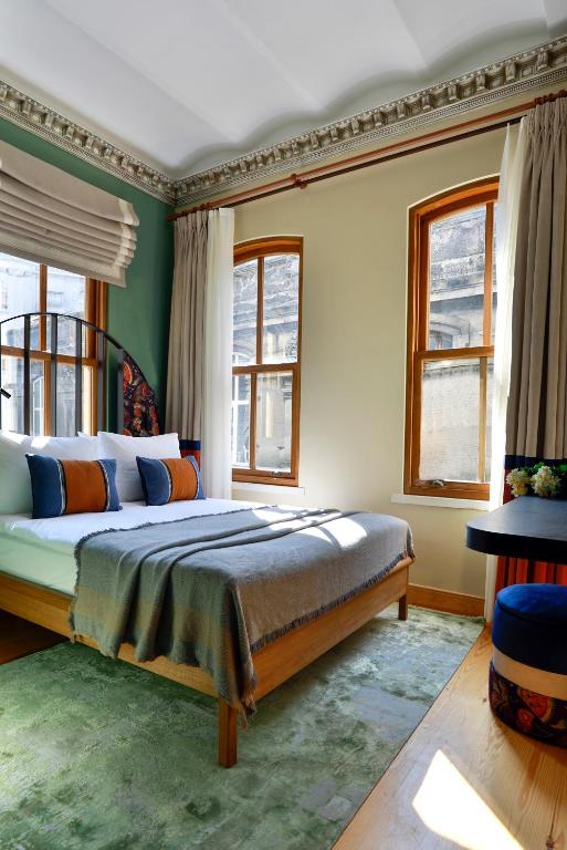 a bedroom with a bed and two windows at Sirin Han Hotel Old City in Istanbul