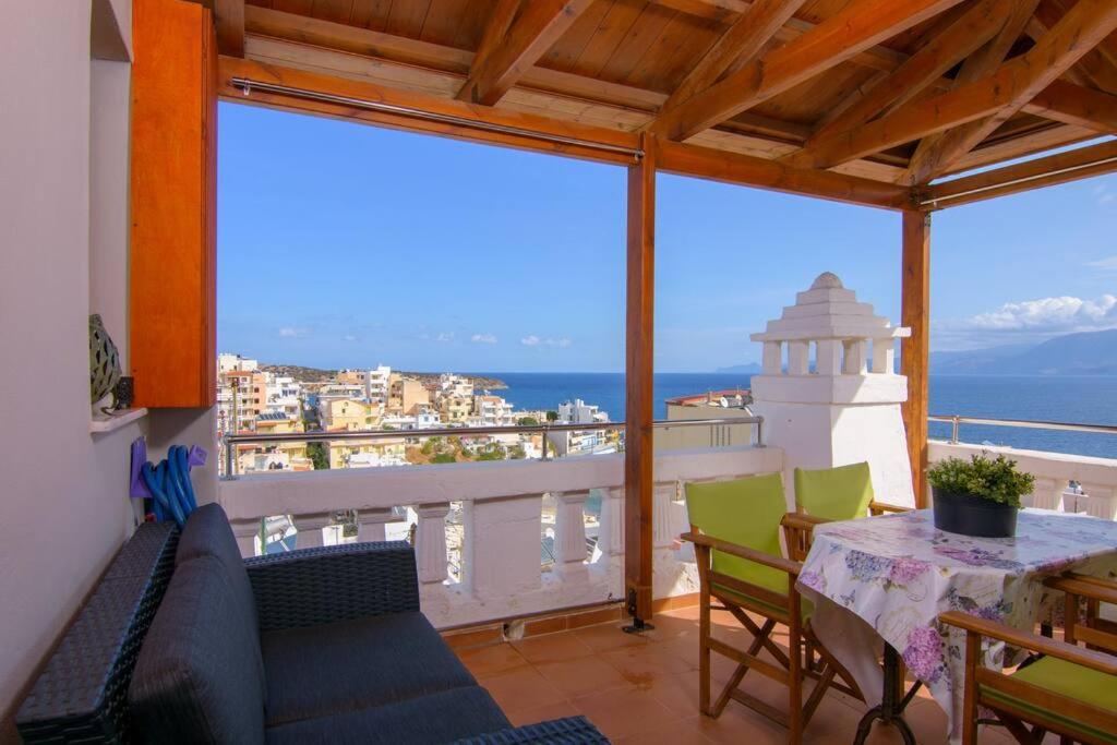 balcón con mesa, sillas y vistas al océano en Beautiful newly apt with sea view, near the center en Agios Nikolaos