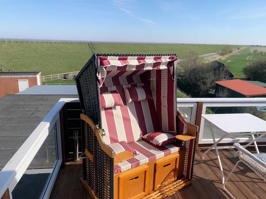 a chair sitting on top of a balcony at Unser Haus am Deich - Wohnung Meerblick in Nordstrand