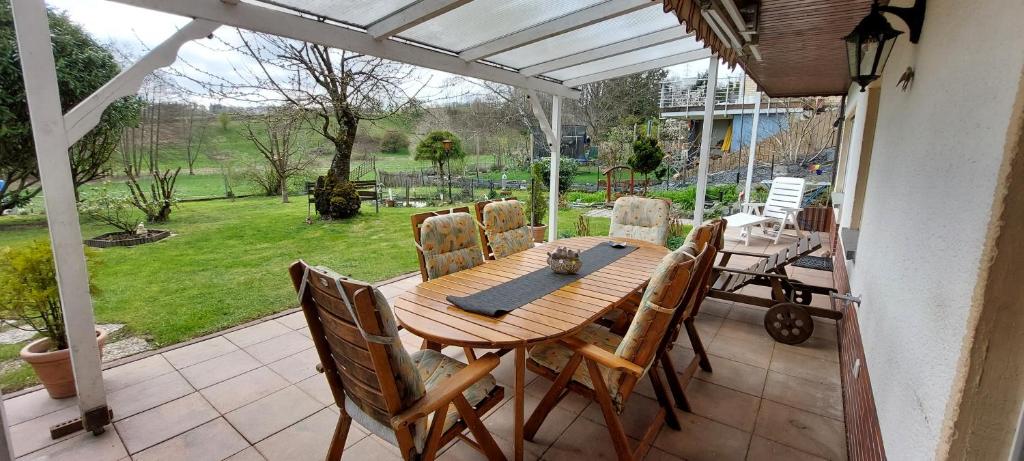 a wooden table and chairs on a patio at Neu renovierte UG Wohnung für bis zu 5 Personen in Mörlenbach