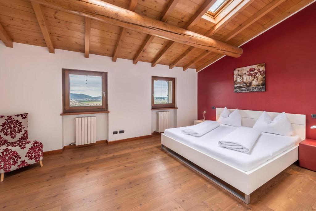 sypialnia z białym łóżkiem i czerwoną ścianą w obiekcie Casa Rustico w mieście Costermano