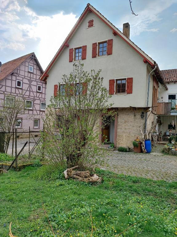 a large white house with red shutters at Relaxen im Taubertal in Niederstetten