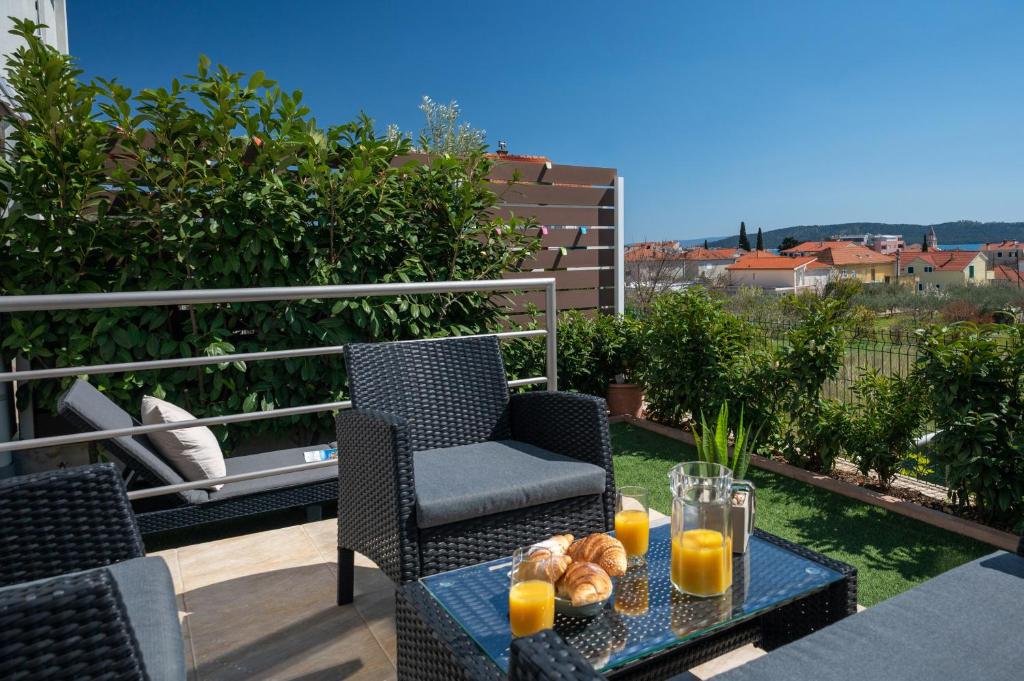 - un balcon avec une table, des chaises et du jus d'orange dans l'établissement Apartment Tikvarin, Kaštel Kambelovac, à Kaštela