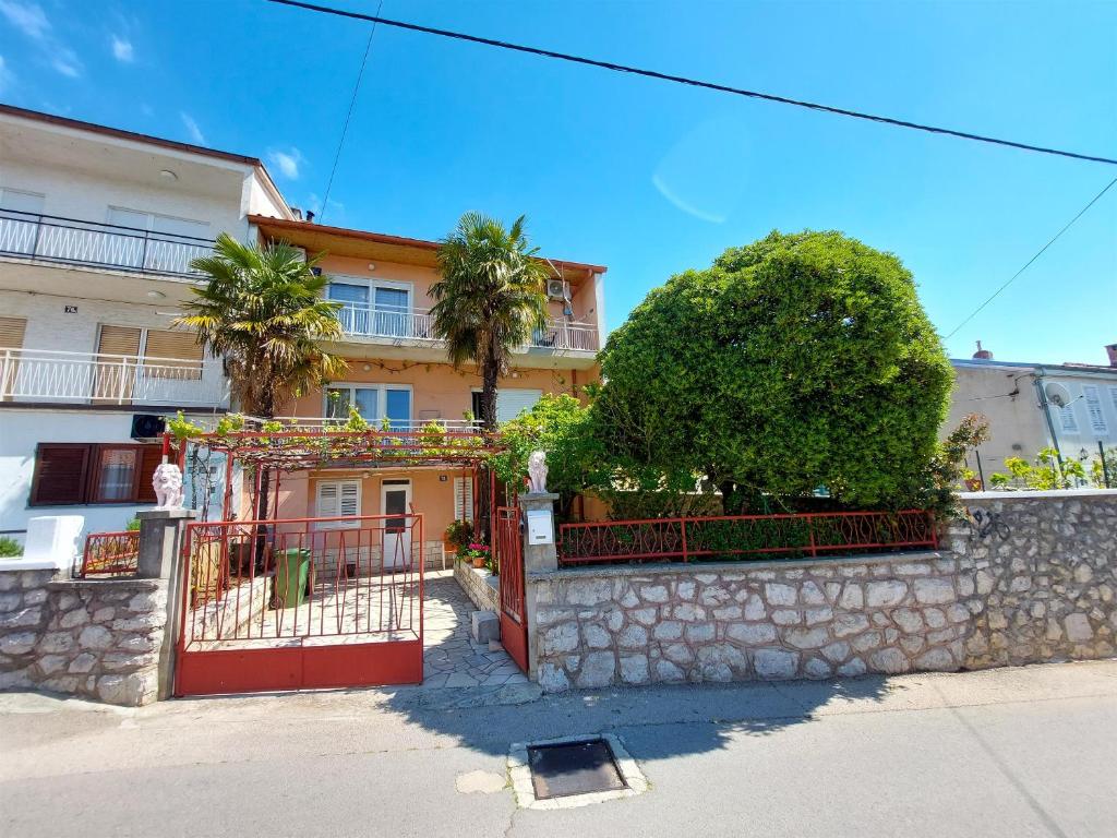 - un bâtiment avec une porte rouge et un mur en pierre dans l'établissement Apartment Tamarut, à Crikvenica