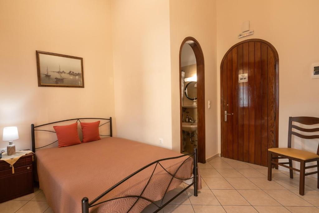 a bedroom with a bed and a table and a chair at Calliope Rooms 1 in Kissamos