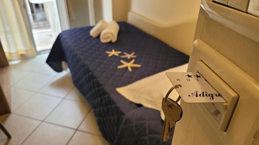 una camera da letto con un letto con un piumone blu di Hotel Adigrat a Riccione