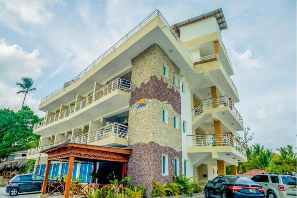 a building with cars parked in front of it at Bella Vida Hotel Punta Cana in Punta Cana