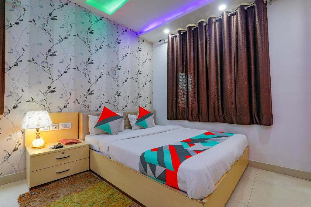um pequeno quarto com uma cama e uma mesa de cabeceira e uma cama sidx sidx sidx em FabExpress Moti Mahal em Varanasi