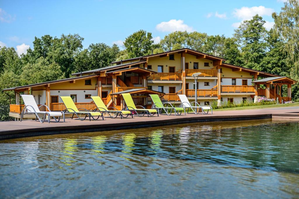 a resort with lounge chairs on a dock next to the water at Welna Eco Spa Resort in Tarusa