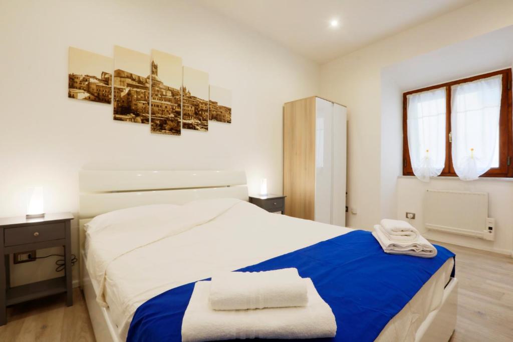 a bedroom with a large bed with blue and white sheets at SweetLittleHouse47 - Dentro le mura, parcheggio gratuito in Siena