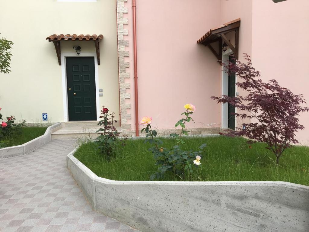 un edificio con una puerta verde y algunas flores en PICCOLO BORGO MOLISANO, en Indiprete