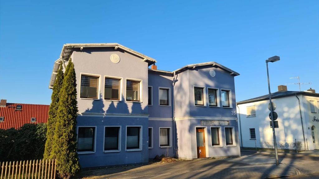 uma casa azul e branca com uma árvore em frente em Haus 4 Jahreszeiten- Fewo Frühling mit Terrasse, Bio-Kamin und 2 Schlafzimmer em Ostseebad Karlshagen
